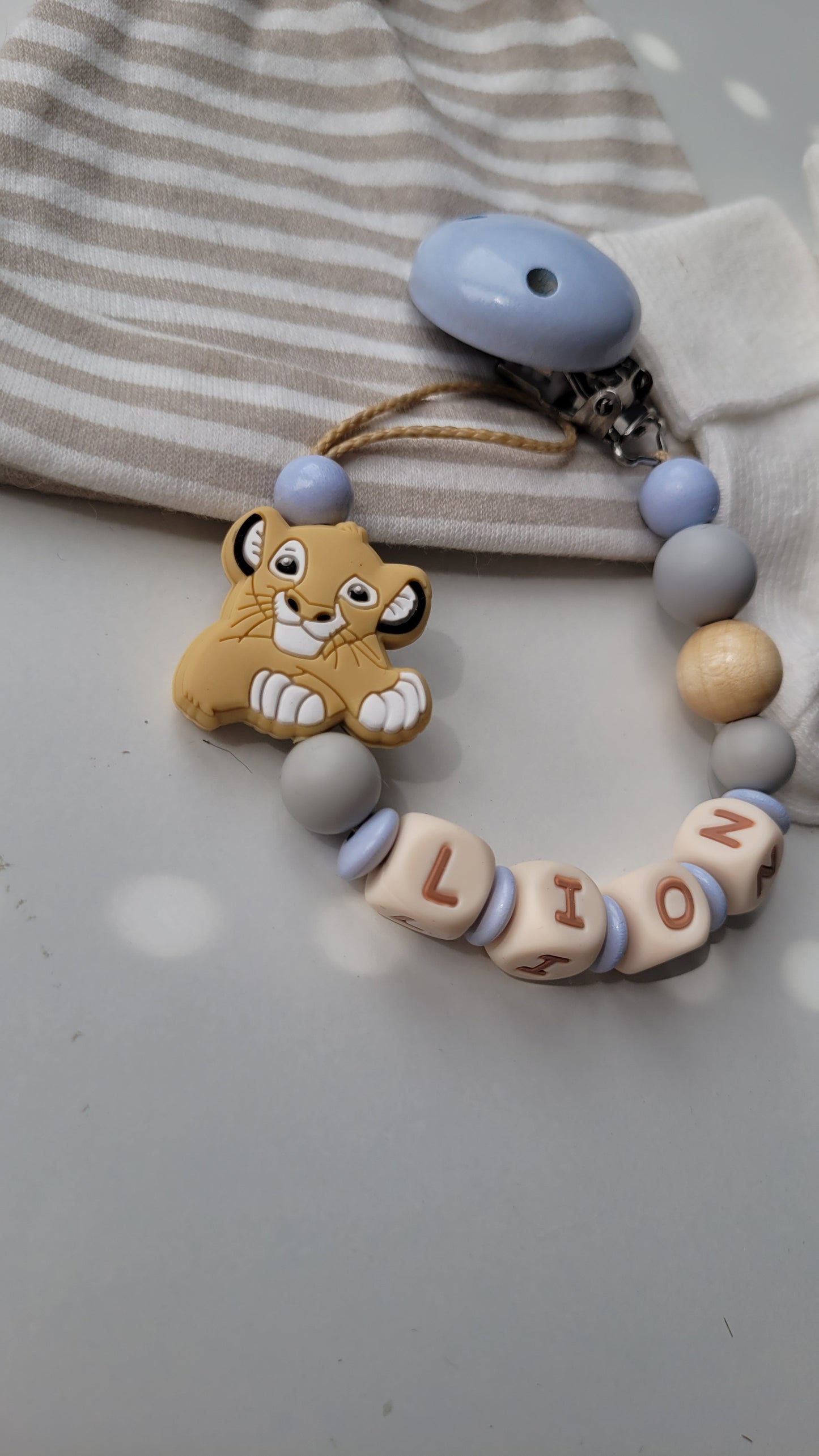 Kinderwagenkette & Schnullerkette mit Namen Löwen & Sterne blau beige