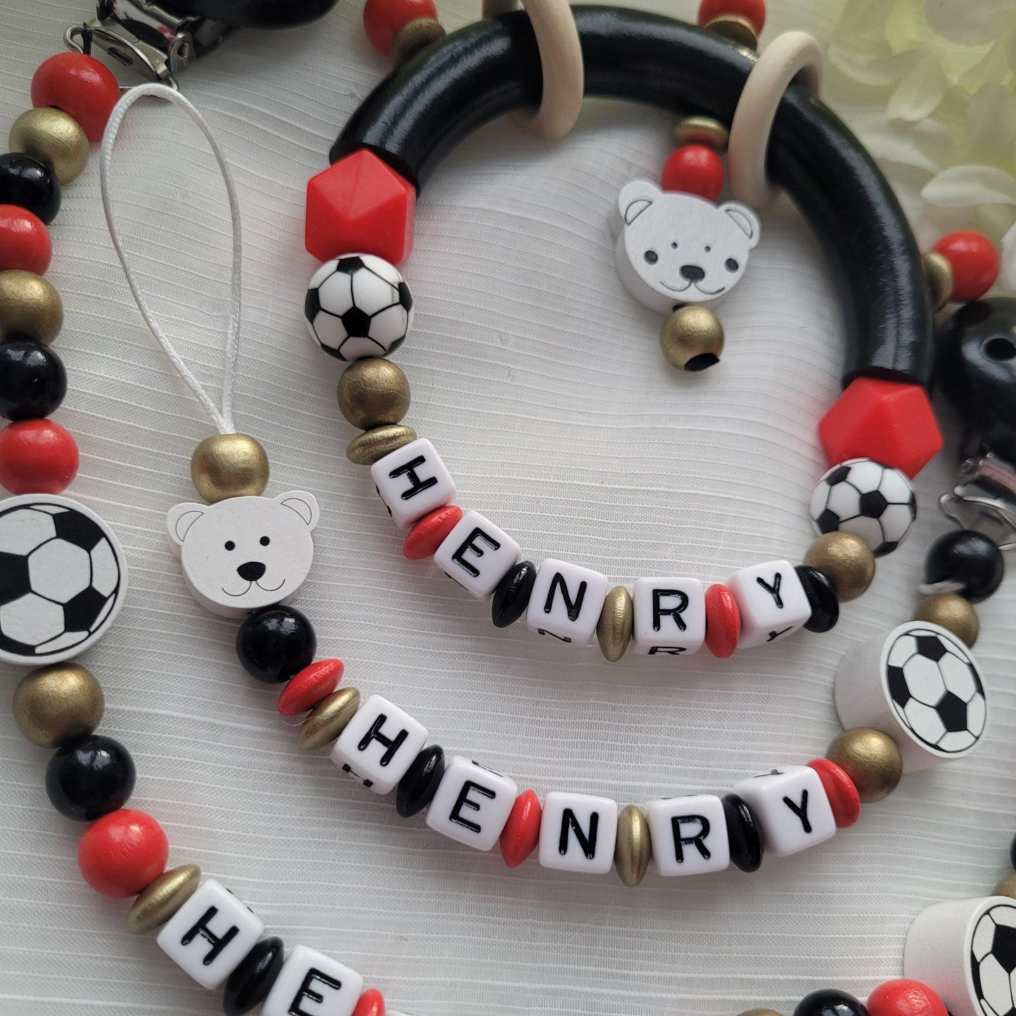 3tlg Set Schnullerkette Kinderwagenkette Greifling Fussball schwarz rot gold
