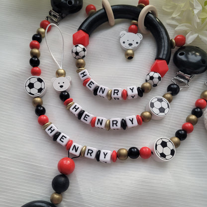 3tlg Set Schnullerkette Kinderwagenkette Greifling Fussball schwarz rot gold