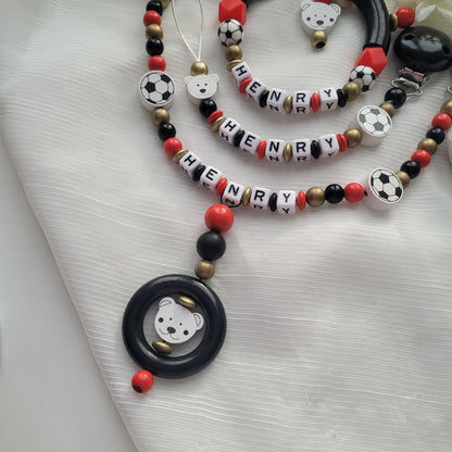 3tlg Set Schnullerkette Kinderwagenkette Greifling Fussball schwarz rot gold