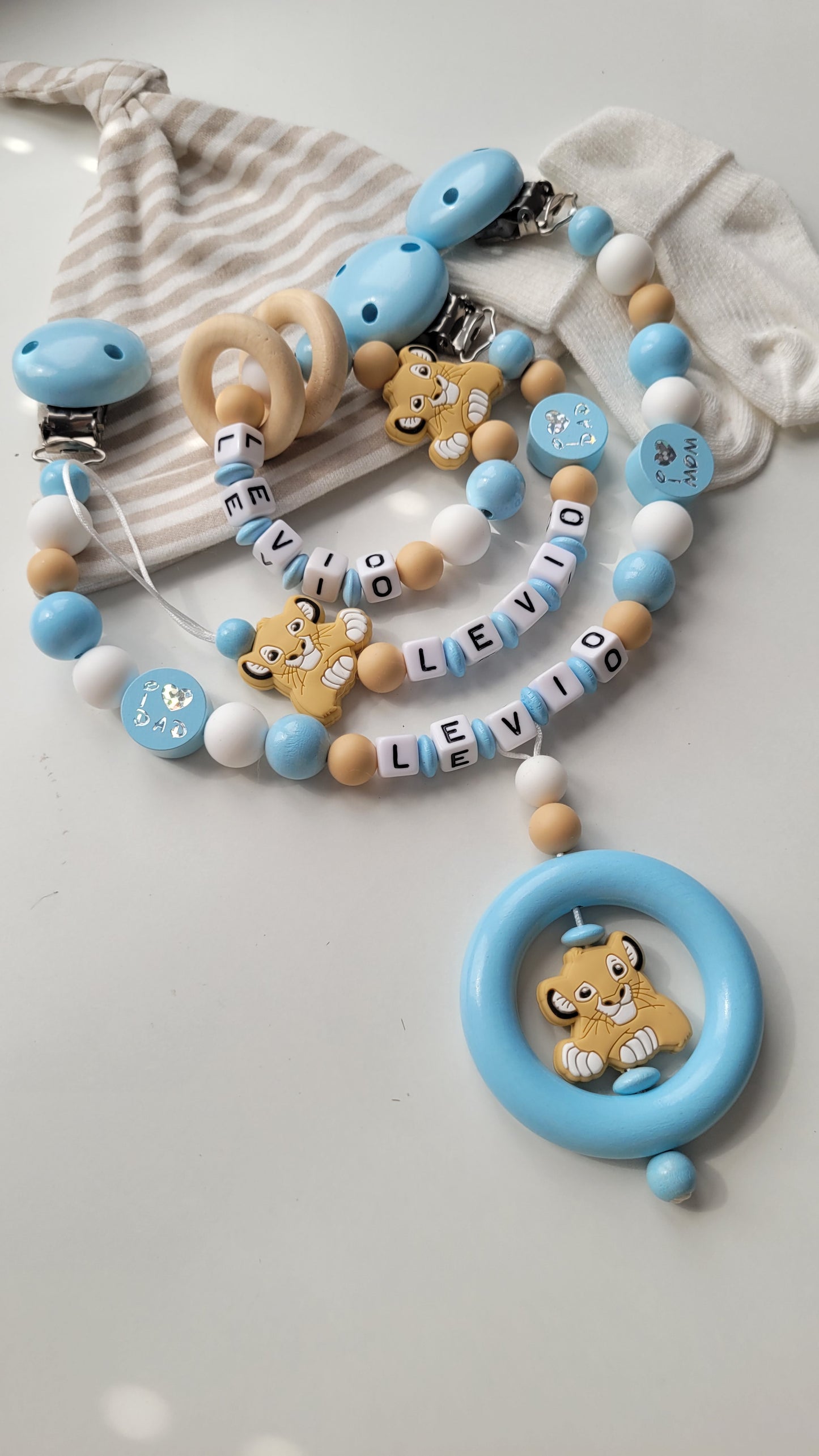 3tlg. Set Schnullerkette Kinderwagenkette & Beissring mit Namen Löwe & i love Mom und Dad blau weiss beige