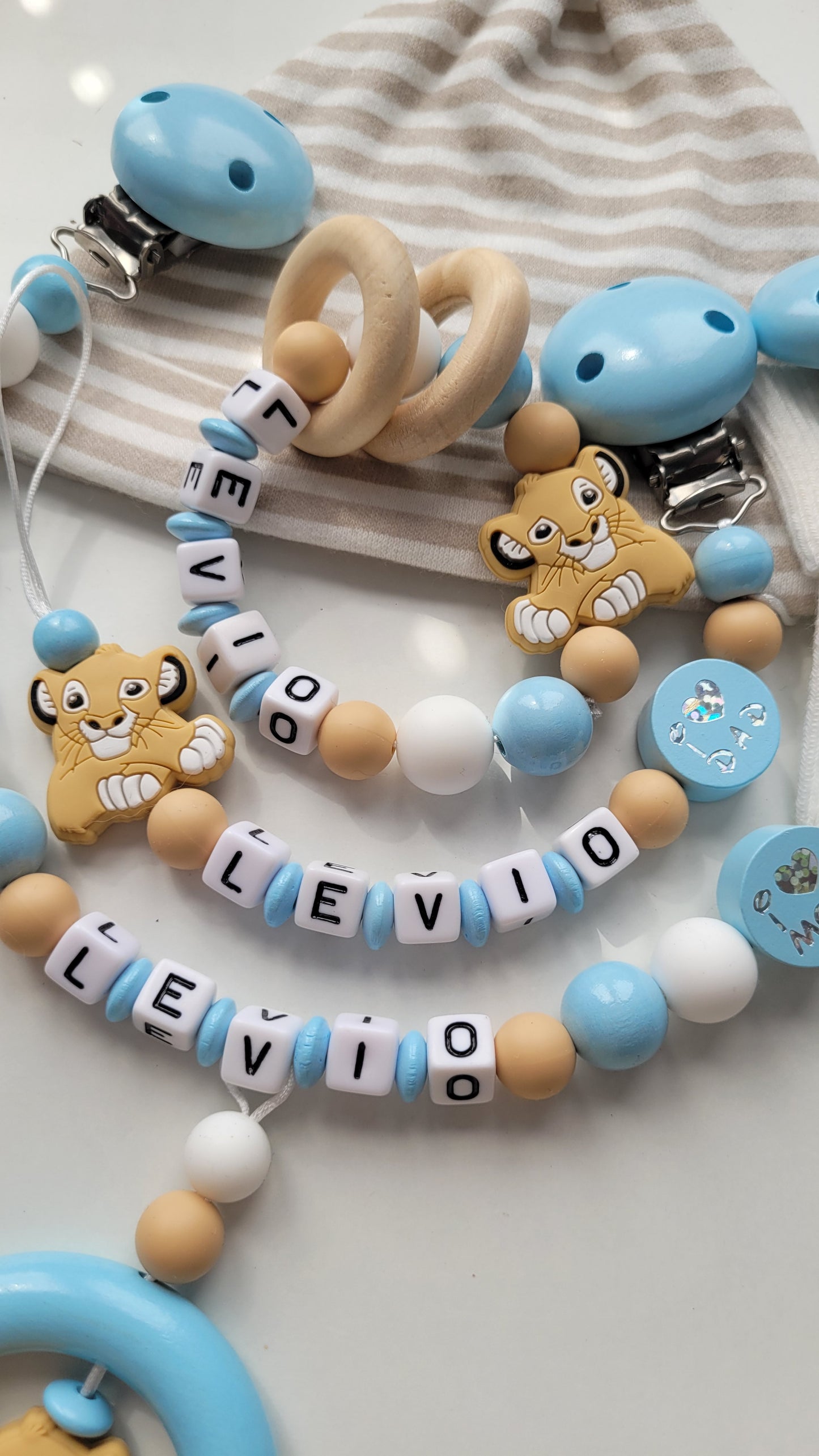 3tlg. Set Schnullerkette Kinderwagenkette & Beissring mit Namen Löwe & i love Mom und Dad blau weiss beige