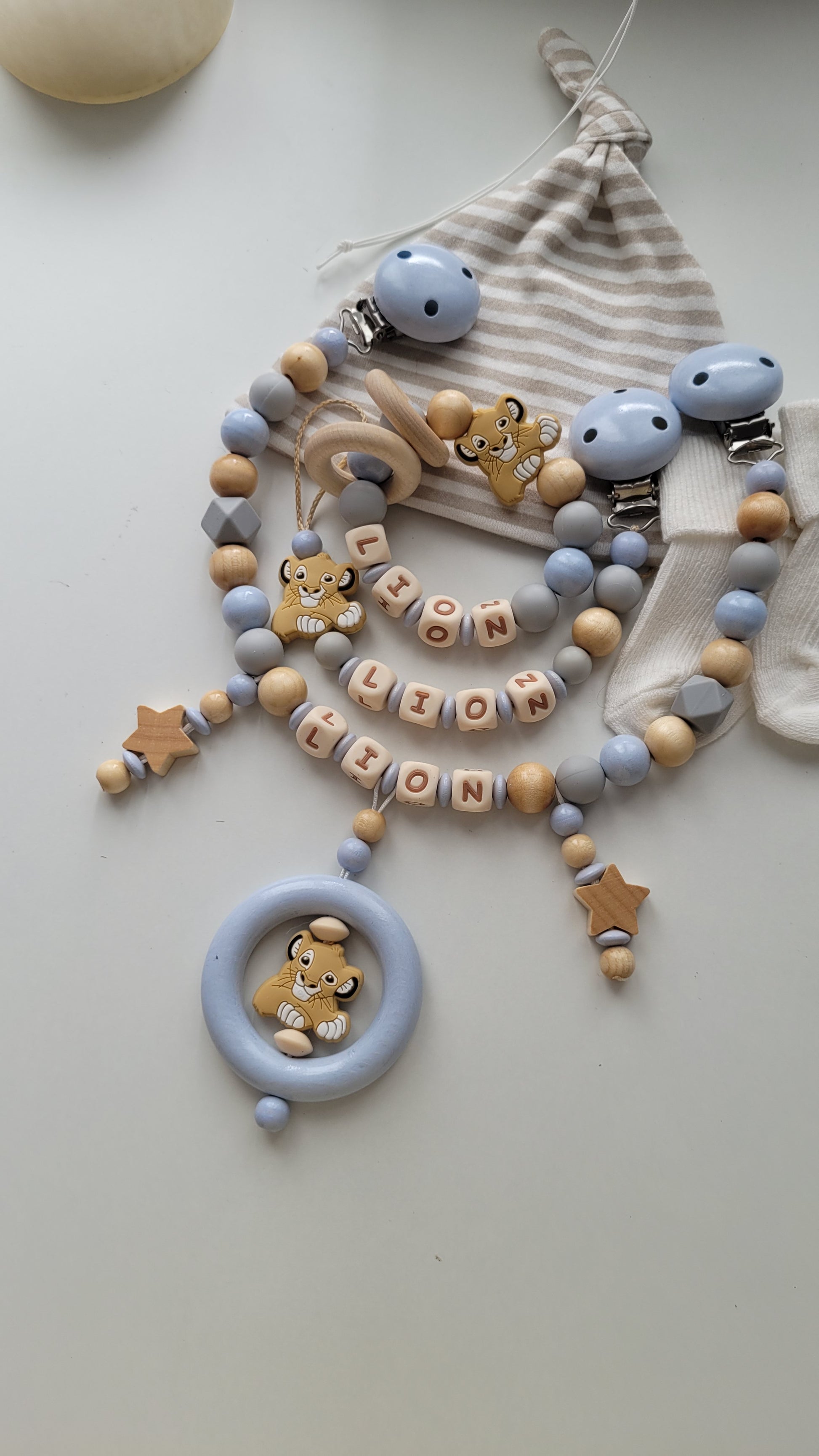 „Handgemachtes 3er Baby-Set mit Namen – Schnullerkette, Kinderwagenkette & Beißring mit Löwen-Motiv & Holzsternen in Blau, Grau & Holz, JULEVI" 