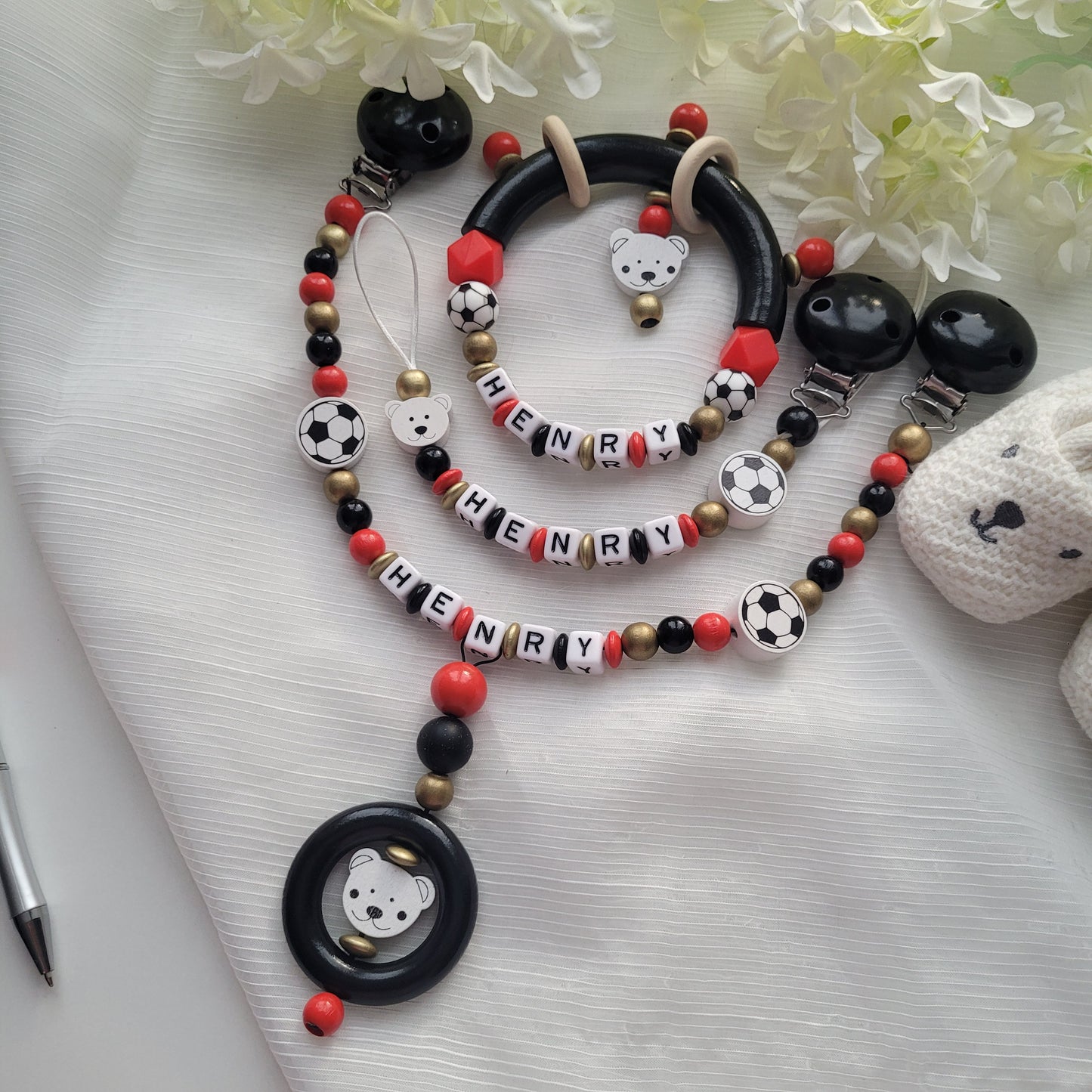 3tlg Set Schnullerkette Kinderwagenkette Greifling Fussball schwarz rot gold