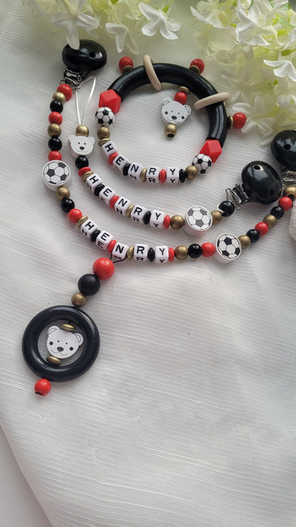 3tlg Set Schnullerkette Kinderwagenkette Greifling Fussball schwarz rot gold
